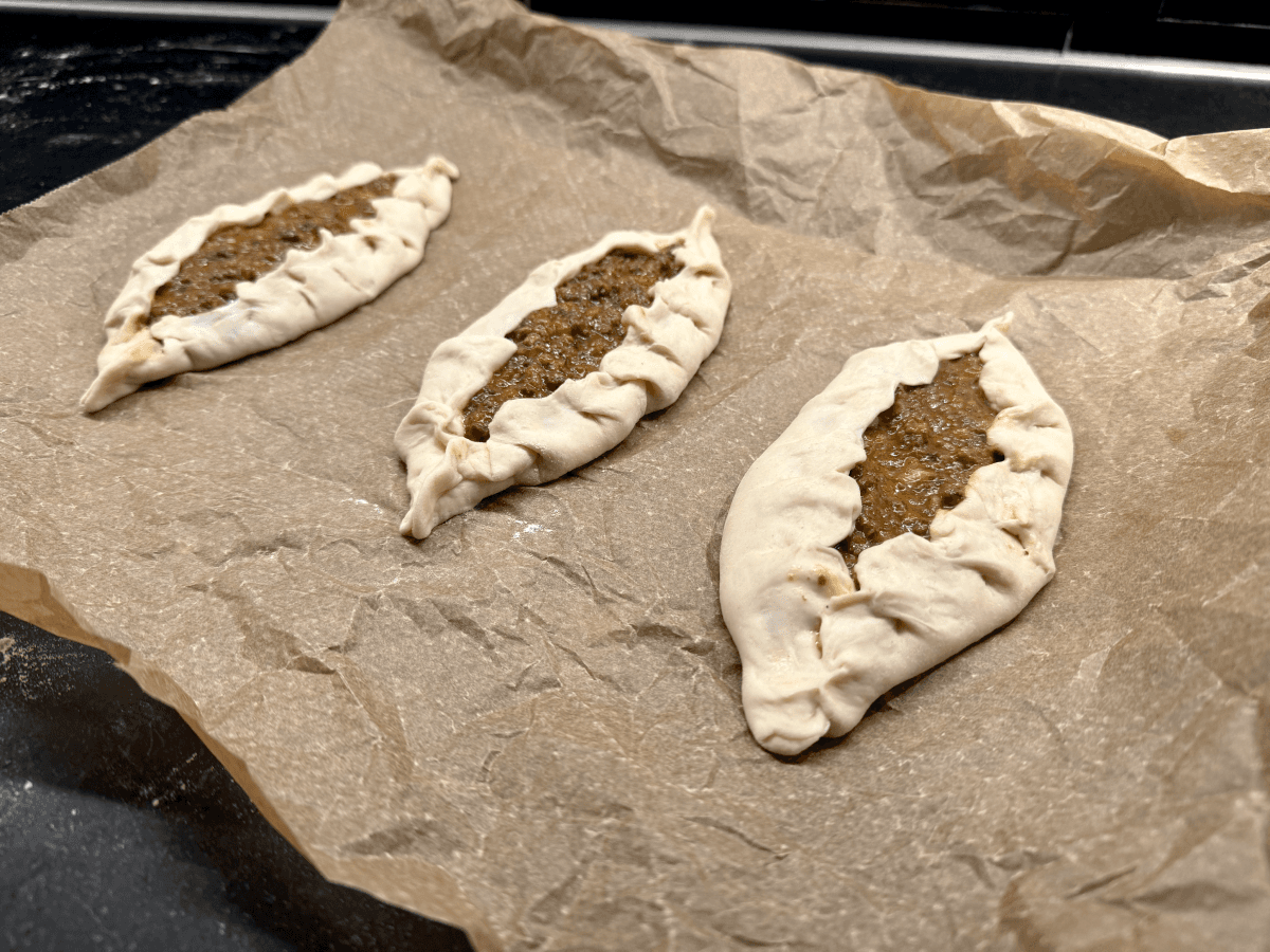 Four perogis on a baking sheet